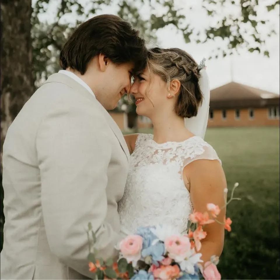 Newlyweds smiling with their foreheads together outdoors