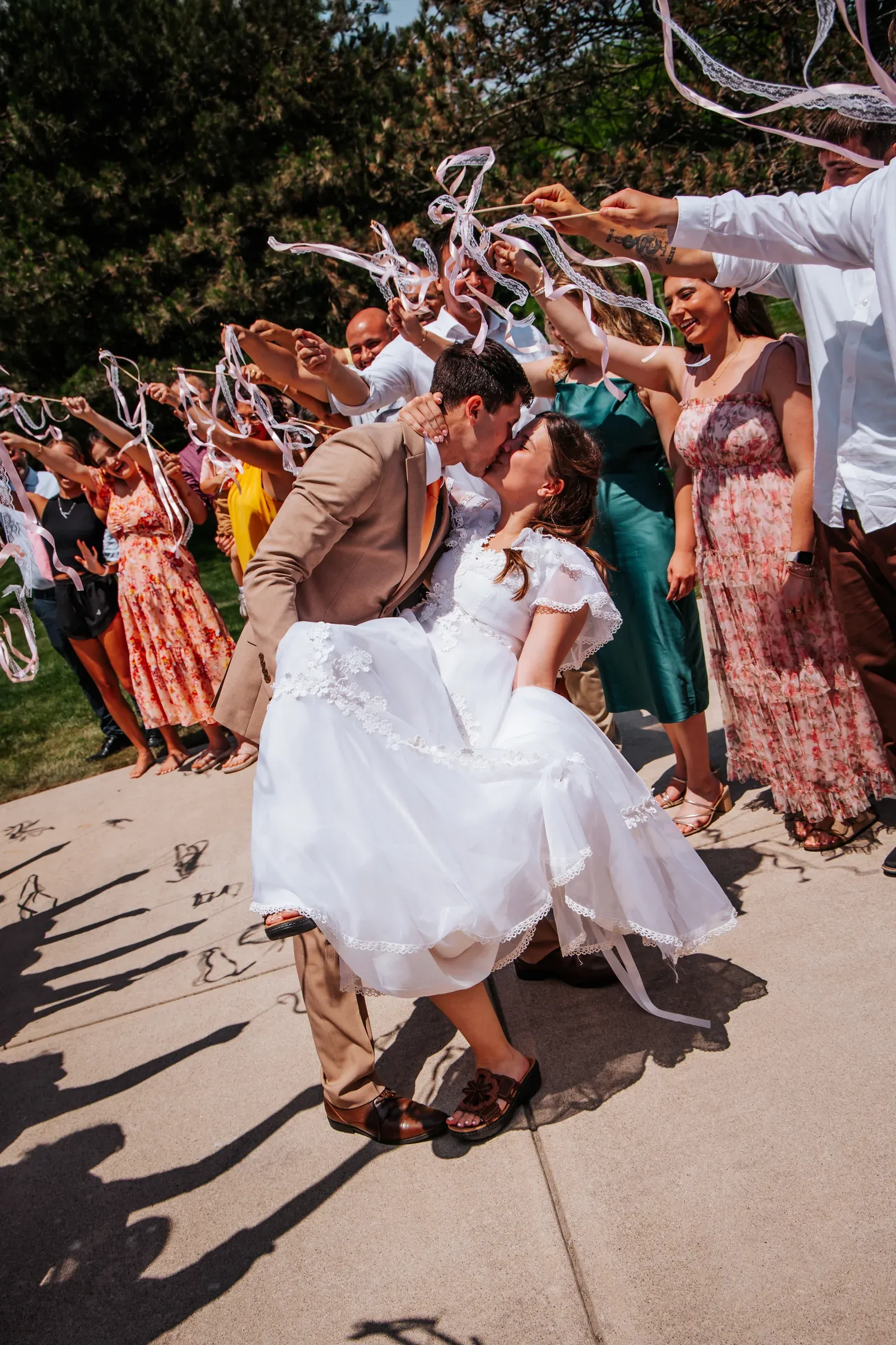 Newlyweds laughing as they leave their ceremony through raised ribbons