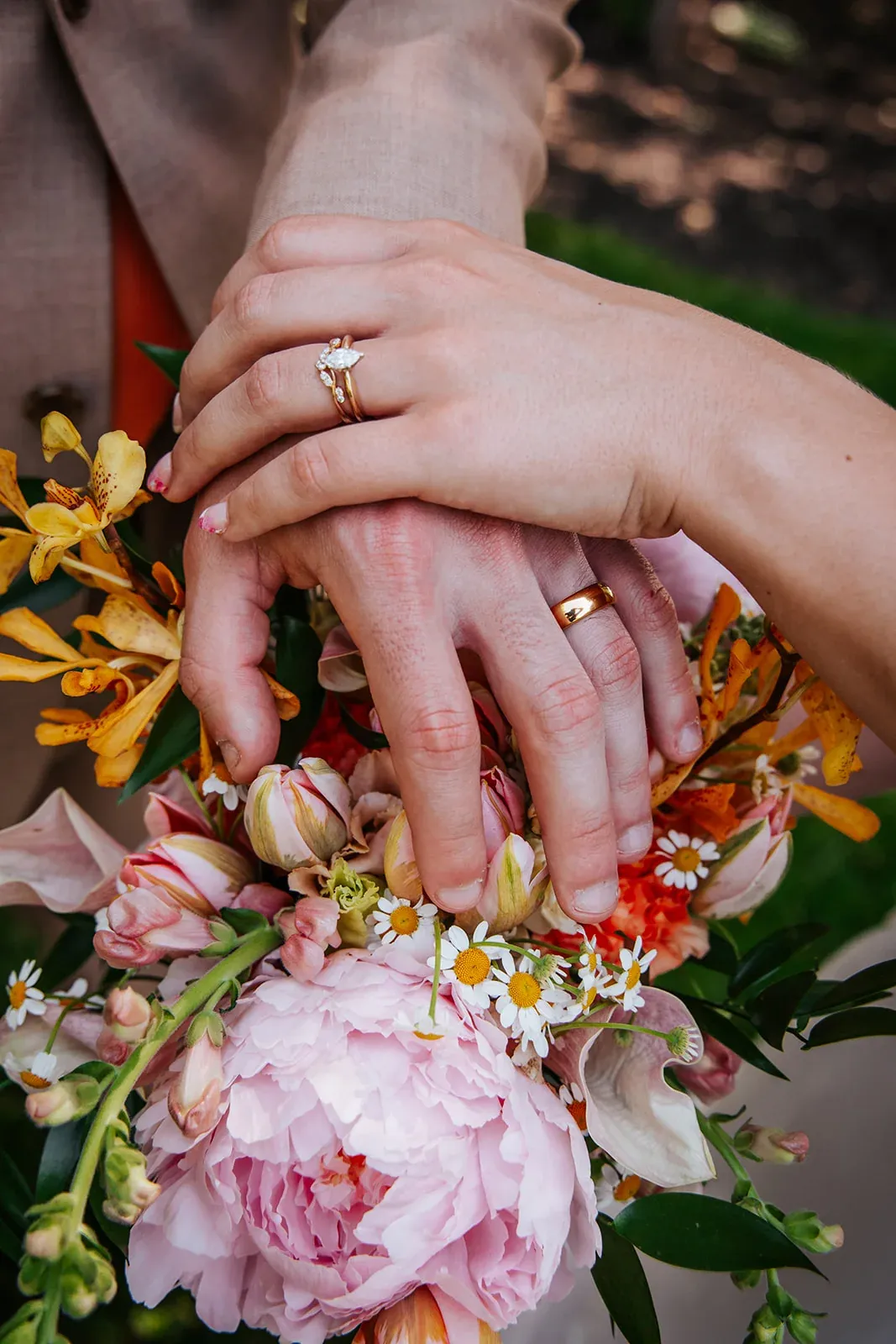 Wedding rings resting on a colorful summer bouquet